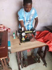 Phillip working at his tailoring business.
