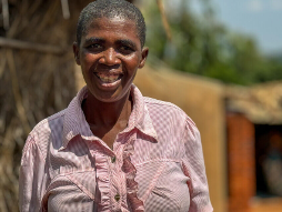 Rose, a member of the Malawi graduation program, poses outside her home in rural Blantyre.